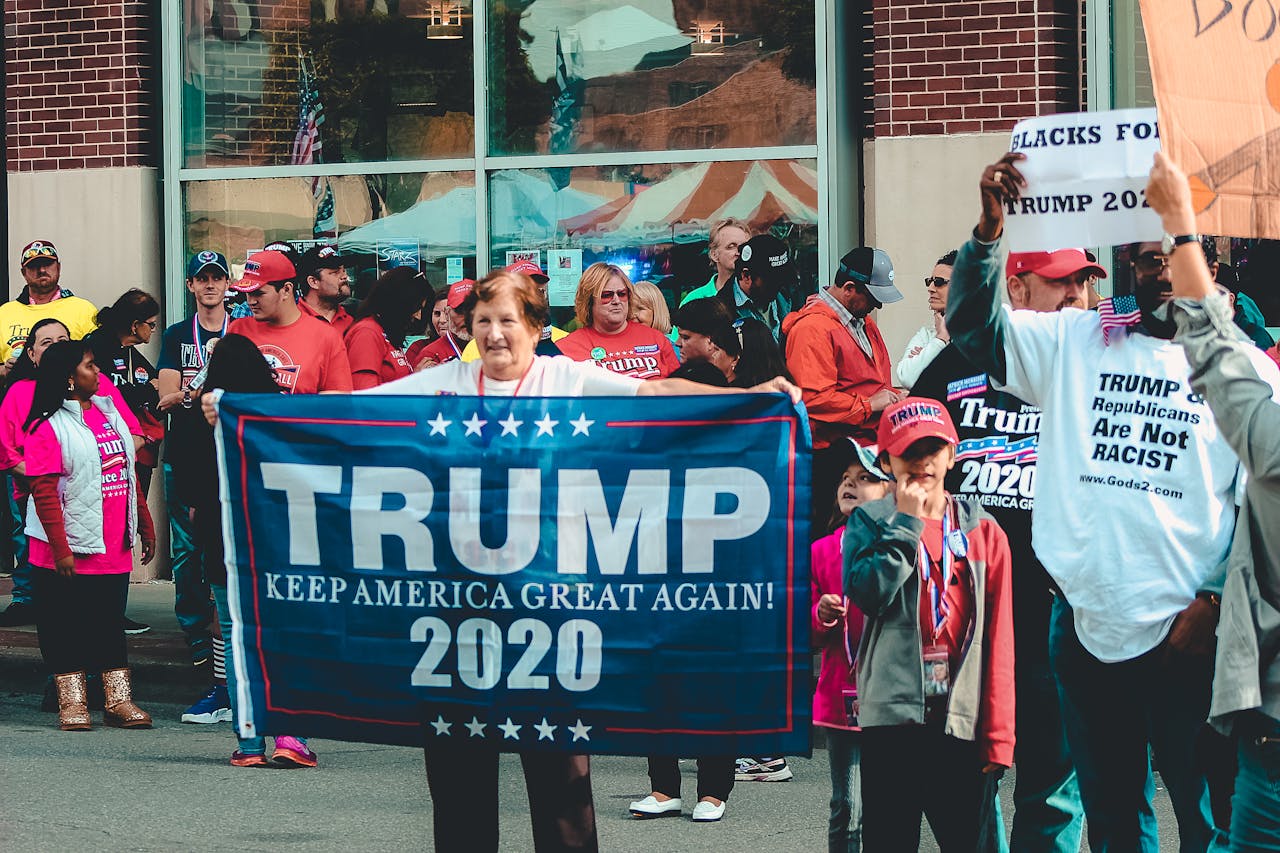 A crowded political rally in Wheeling, showcasing Trump supporters with banners and signs.